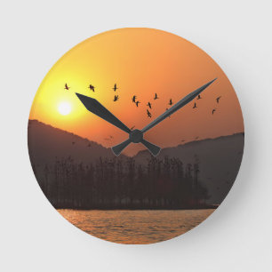 Birds Flying in Sunset Sky Over East Lake Round Clock