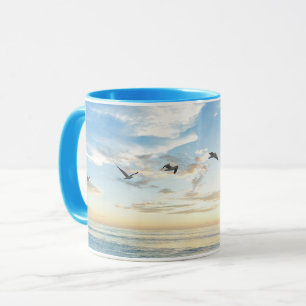 Birds in flight over the ocean mug