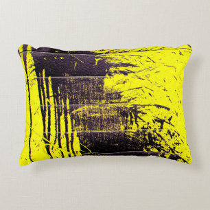 Black abstract splatter paint drips on a bright ye decorative cushion