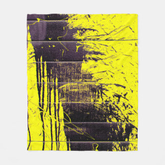 Black abstract splatter paint drips on a bright ye fleece blanket