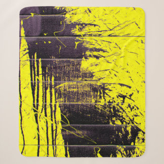 Black abstract splatter paint drips on a bright ye sherpa blanket