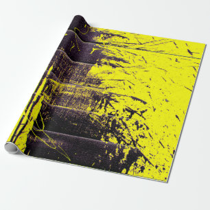 Black abstract splatter paint drips on a bright ye wrapping paper