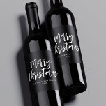 Black and White Brush Script Merry Christmas Wine Label<br><div class="desc">Festive holiday wine labels featuring "Merry Christmas" displayed in white brush script lettering with a black background. Personalize the Merry Christmas wine labels with your family name and the year displayed in white lettering.</div>