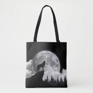 Black and white wolf howling at the moon tote bag