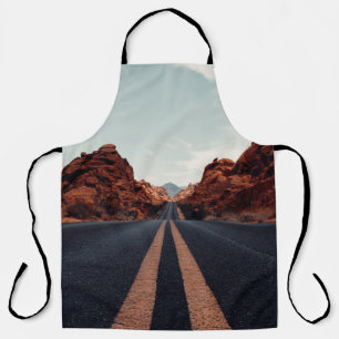 BLACK ASPHALT ROAD BETWEEN BROWN ROCK FORMATION UN APRON