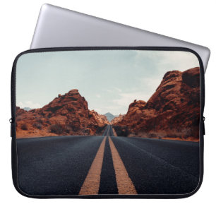 BLACK ASPHALT ROAD BETWEEN BROWN ROCK FORMATION UN LAPTOP SLEEVE
