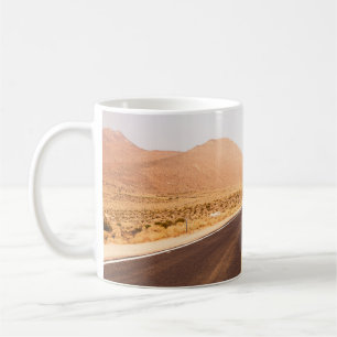BLACK ASPHALT ROAD IN THE MIDDLE OF BROWN FIELD COFFEE MUG