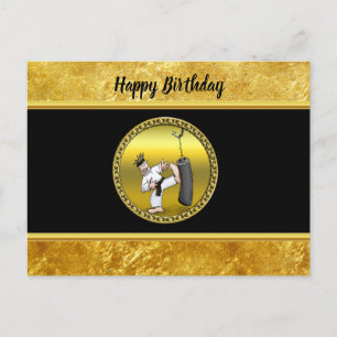 Black belt karate man kicking a black training bag postcard