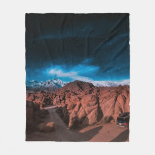 BLACK CAR NEAR ROCK FORMATIONS FLEECE BLANKET