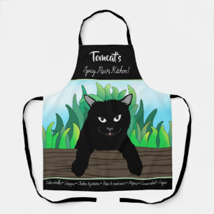 Black cat on fence with green grass apron