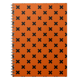 Black cross stitches on orange notebook