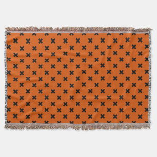 Black cross stitches on orange throw blanket
