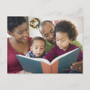 Black family reading book together postcard