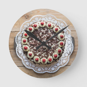 Black Forest cake on rustic wood Round Clock