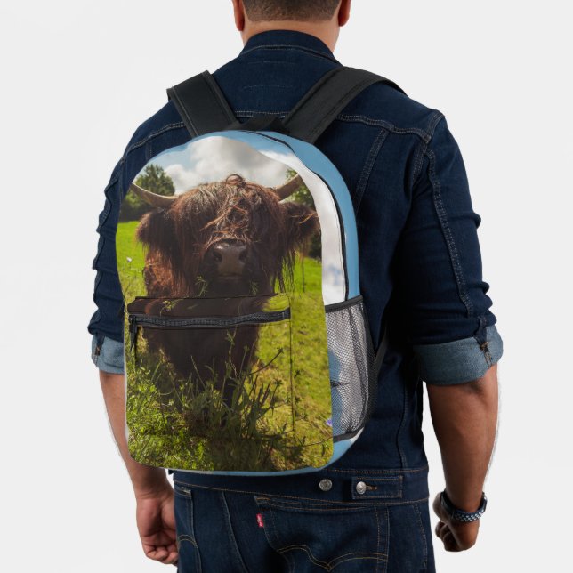 Black highland cow grazing green field sun light printed backpack (Insitu (Model))
