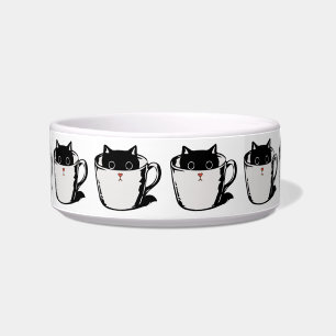 Black kitten with red nose hiding in a cup bowl