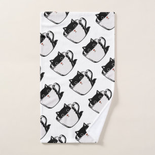Black kitten with red nose hiding in a cup hand towel