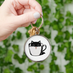 Black kitten with red nose hiding in a cup key ring