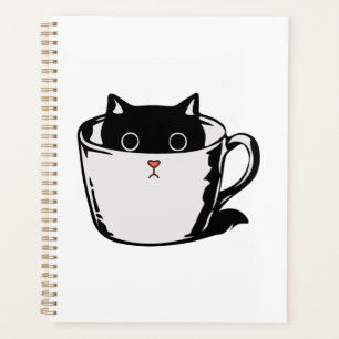 Black kitten with red nose hiding in a cup planner
