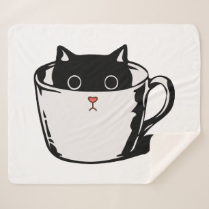 Black kitten with red nose hiding in a cup sherpa blanket