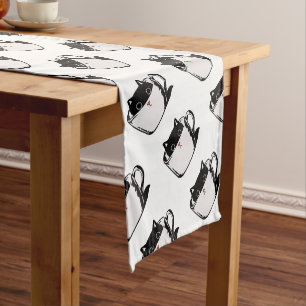 Black kitten with red nose hiding in a cup short table runner