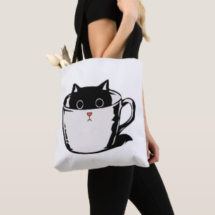 Black kitten with red nose hiding in a cup tote bag