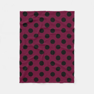 Black polka dots on burgundy fleece blanket