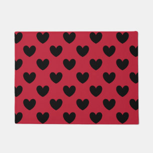 Black polka hearts on red doormat
