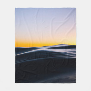 BLACK SAND UNDER ORANGE SKY DURING SUNSET FLEECE BLANKET