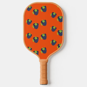 Blackberry fruit on orange pickleball paddle