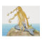 Blonde mermaid sitting on sea rock, side view.