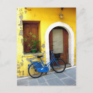 Blue bicycle against a yellow wall postcard