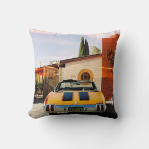 Blue car parked beside brown concrete building in  cushion