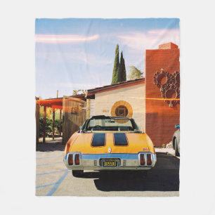 Blue car parked beside brown concrete building in fleece blanket