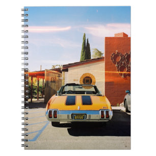 Blue car parked beside brown concrete building in  notebook