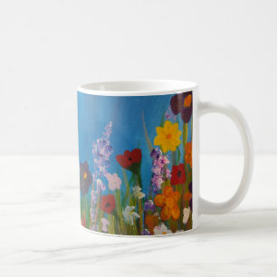 Blue cornflowers in a meadow of wildflowers coffee mug