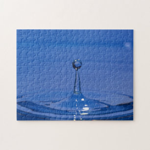 Blue drop of water in motion on a jigsaw puzzle