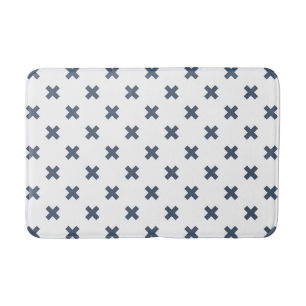 Blue-grey cross stitches on white bath mat