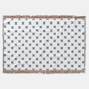 Blue-grey cross stitches on white throw blanket