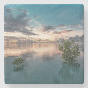 blue sky with red and dark clouds reflected on sea stone coaster