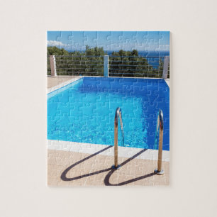 Blue swimming pool with steps at sea jigsaw puzzle