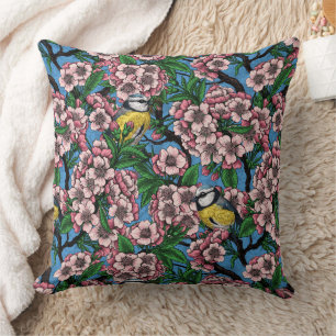Blue tit birds in the blooming cherry tree on blue cushion