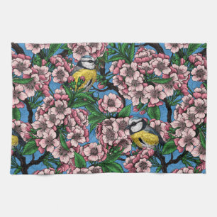 Blue tit birds in the blooming cherry tree on blue tea towel