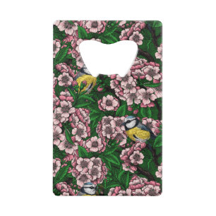 Blue tit birds in the blooming cherry tree on gree