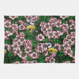 Blue tit birds in the blooming cherry tree on gree tea towel