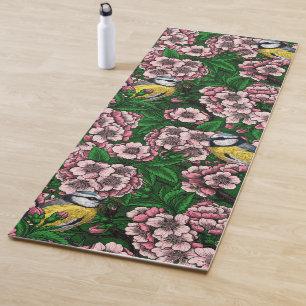 Blue tit birds in the blooming cherry tree on gree yoga mat