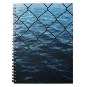 Body of water in front of chain link fence notebook