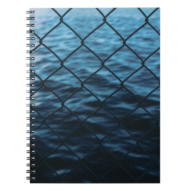 Body of water in front of chain link fence notebook (Front)