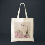 Bonjour Vintage Eiffel Tower & Pink Flowers Tote Bag<br><div class="desc">A whimsical vintage collage which has an old french postcard background with an eiffel tower sketch and some pink and white wildflowers bordering the bottom. Fancy swirly embellishments decorate the sides. Bonjour written in a black handwritten font.</div>