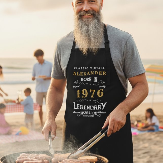 "Born in 1976" Grill Master Apron for Men (Man wearing a personalized apron while BBQ'ing at a beach )
